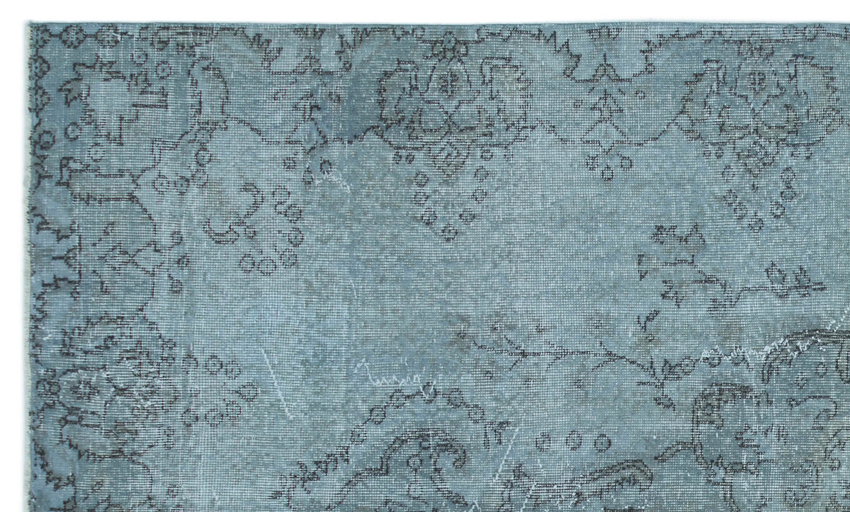 Dusty blue rug with a distressed, dark grey traditional floral medallion pattern.