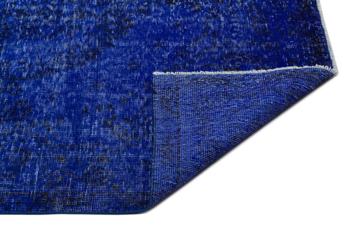 Load image 1 in gallery view. Cobalt blue distressed rug with a black vintage-style pattern, shown with a folded corner on a white background.