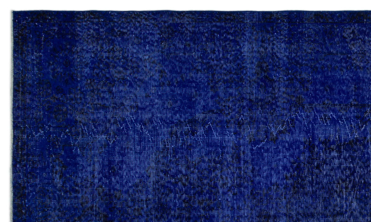 Deep blue vintage-style rug with a distressed, overdyed texture and subtle black tonal variations.