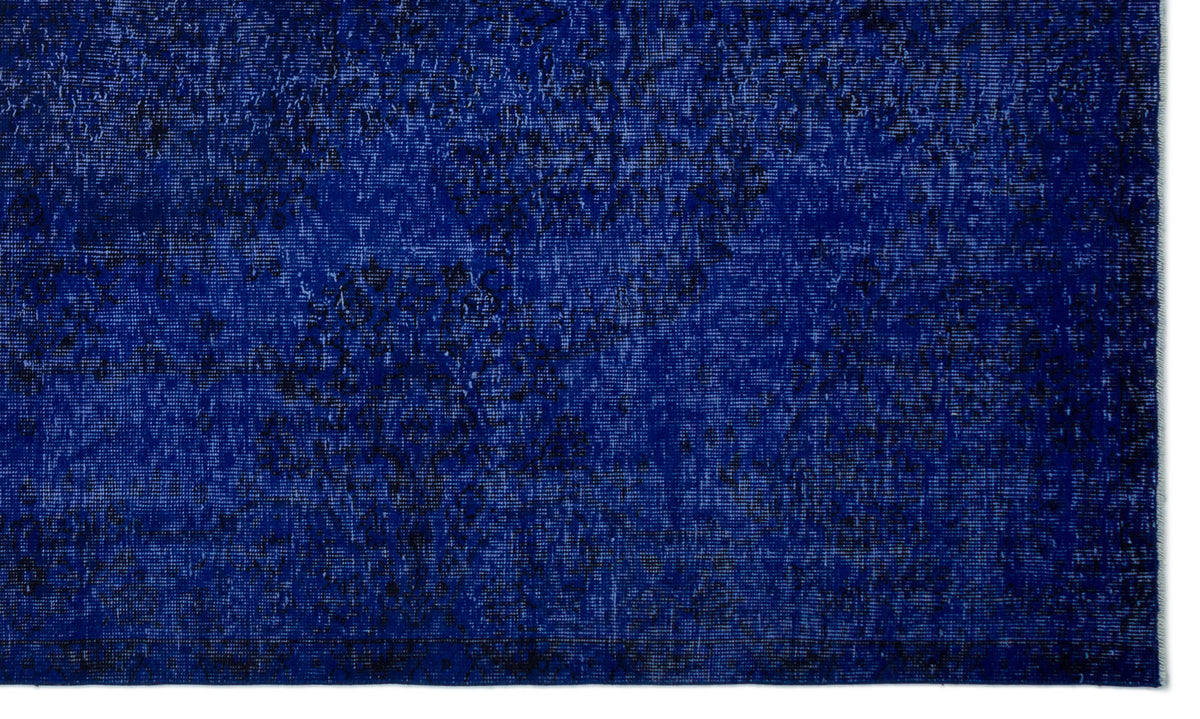 Deep blue rug with a distressed, mottled texture and subtle black vintage-style pattern.