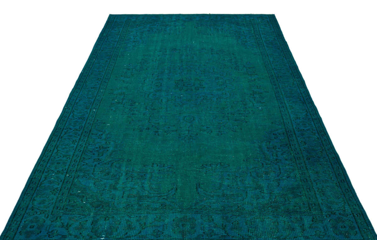 Teal monochromatic rug with a traditional distressed medallion pattern on a white background.