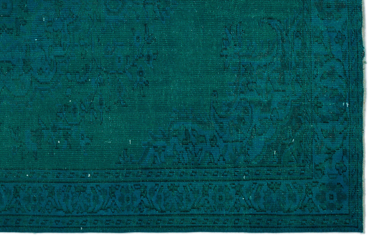 Teal monochromatic rug with a traditional distressed floral medallion pattern and a detailed border.