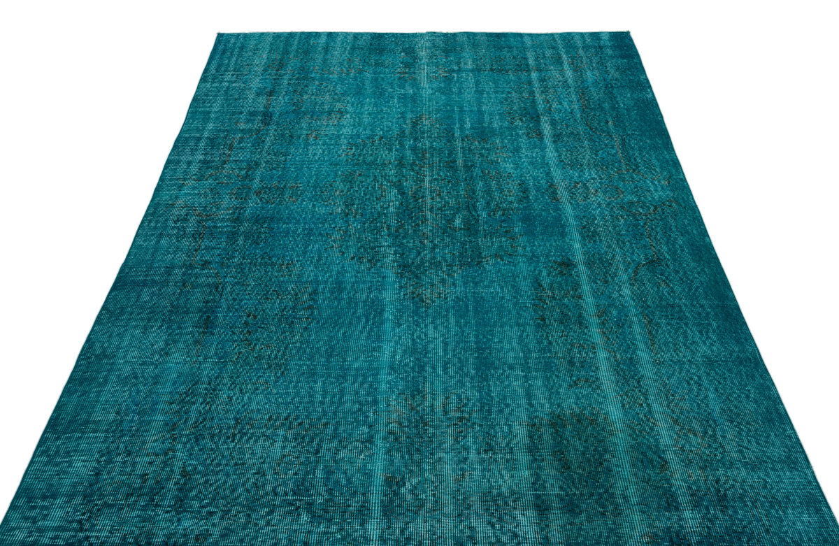 Teal distressed area rug with a faded traditional medallion pattern on a white background.