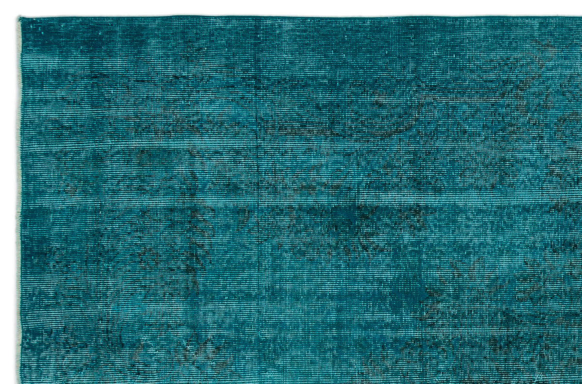 Teal distressed rug with a faded, horizontal linear texture and subtle dark charcoal vintage-style motifs.