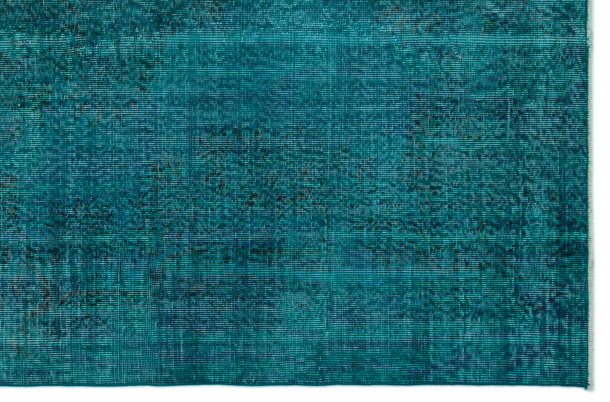 Teal distressed rug with a faded, low-pile texture and subtle dark charcoal worn-in detailing.