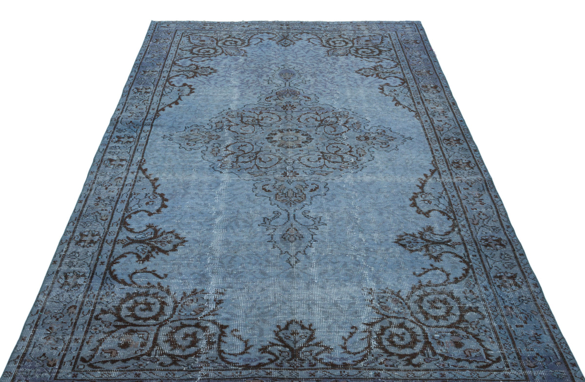 Distressed blue rug with a dark brown traditional floral medallion and border pattern on a white background.