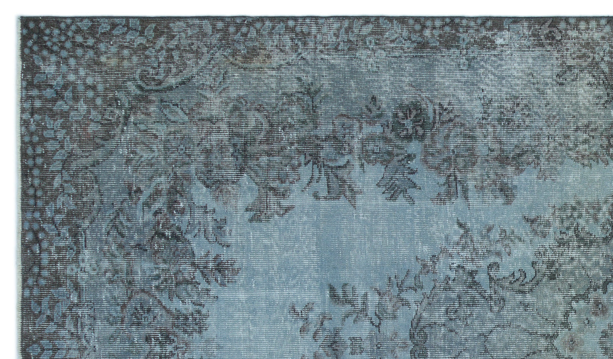 Blue and charcoal grey distressed rug with a traditional floral medallion pattern.
