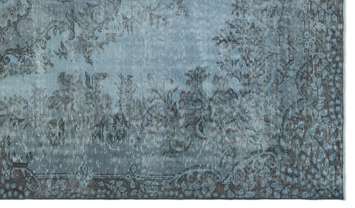 Blue and charcoal grey rug with a distressed, traditional floral medallion pattern.