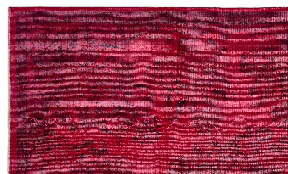 Vibrant magenta rug with a distressed black floral medallion pattern and a thin border.