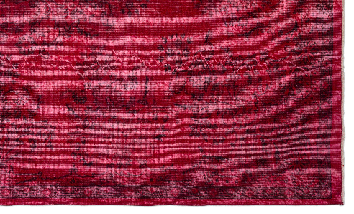 Vibrant red rug with a distressed black floral medallion pattern and a thin border.