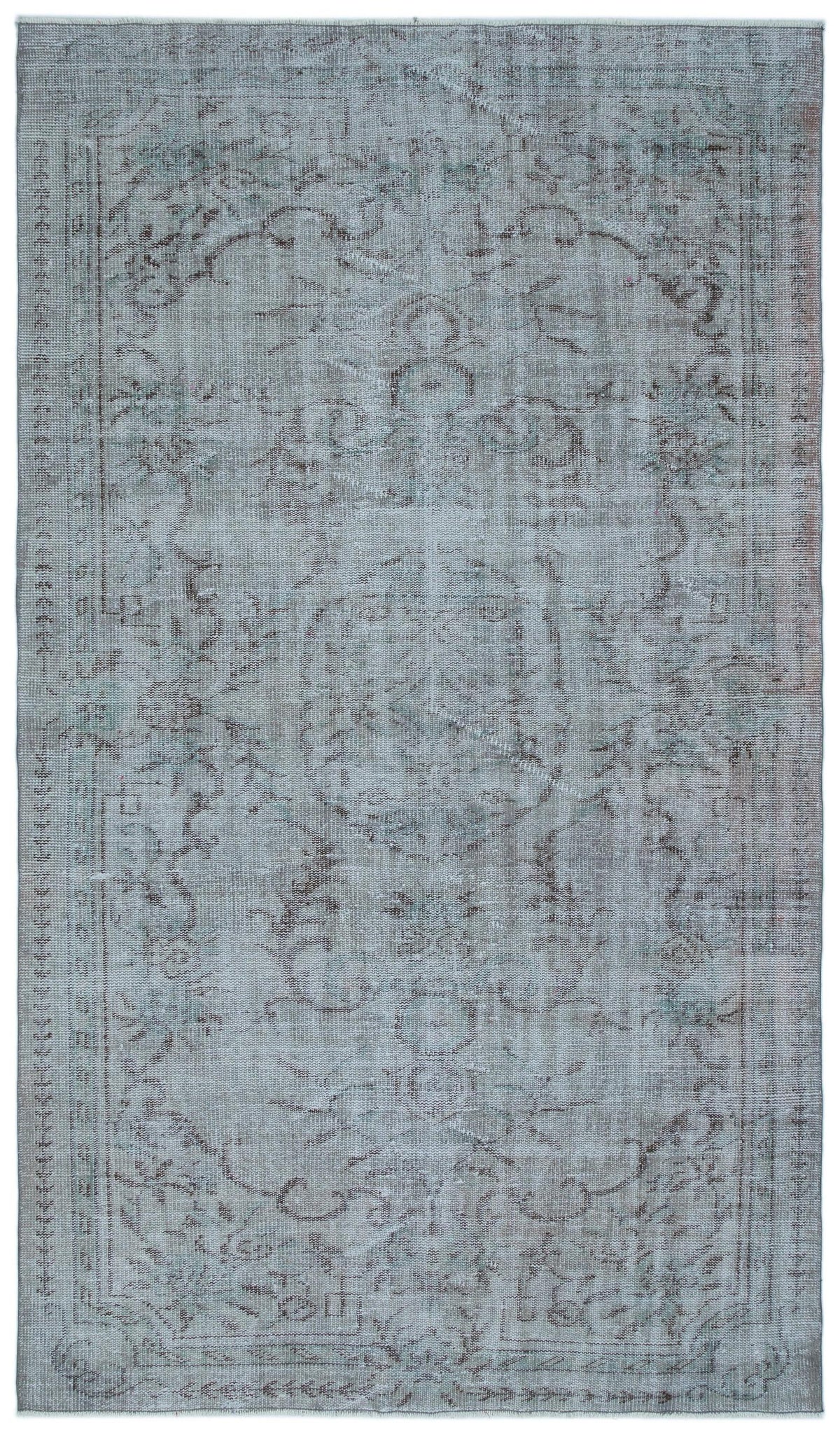 Faded blue and grey distressed rug with a traditional central medallion and ornate floral border.