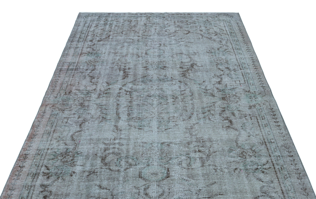 Light blue and grey distressed rug with a faded traditional medallion pattern on a white background.