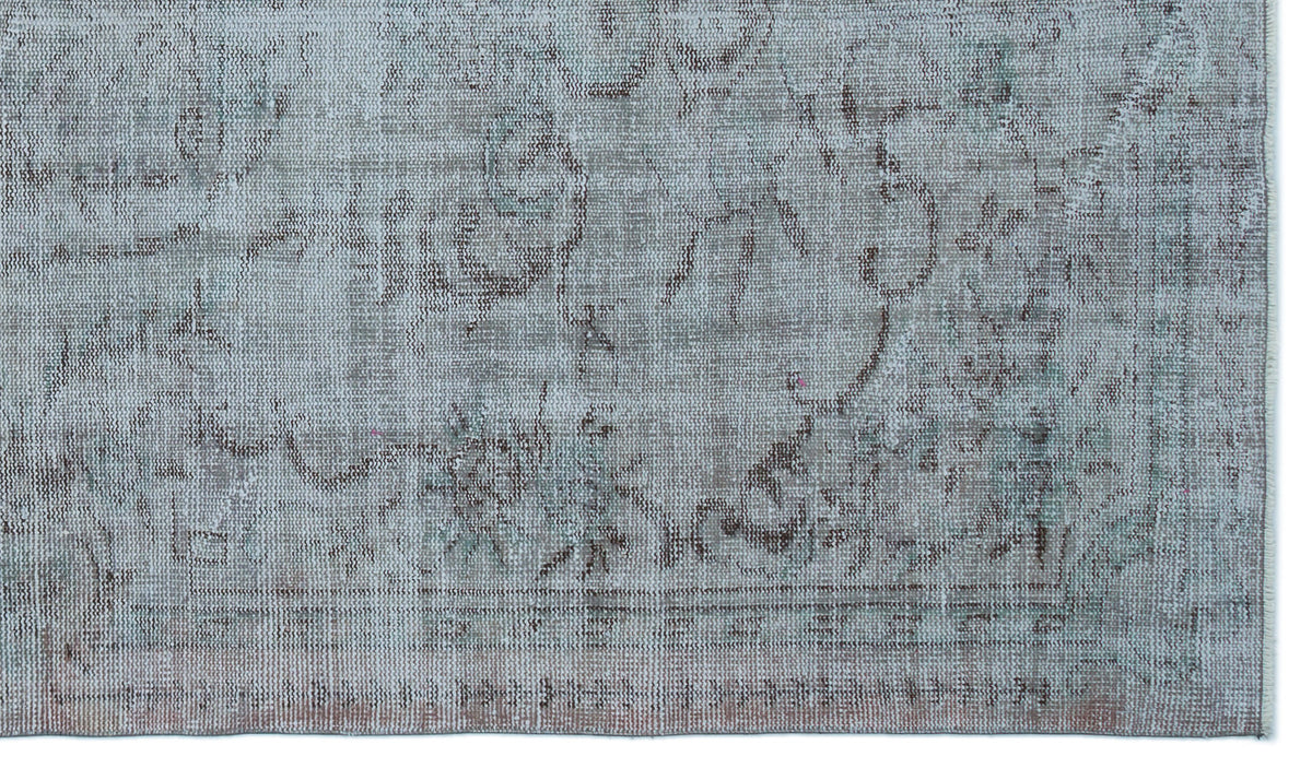 Distressed light blue and grey rug with a faded traditional medallion pattern and a bordered edge.