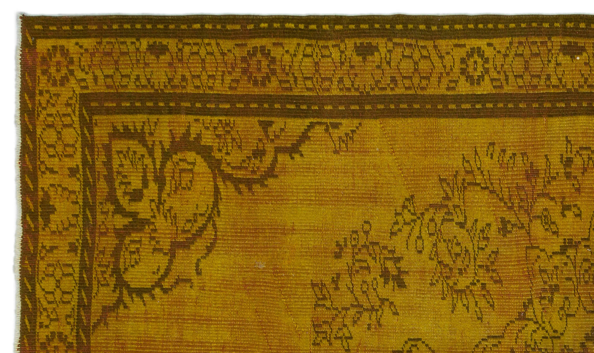 Mustard yellow rug with a dark brown floral border and intricate botanical motifs.