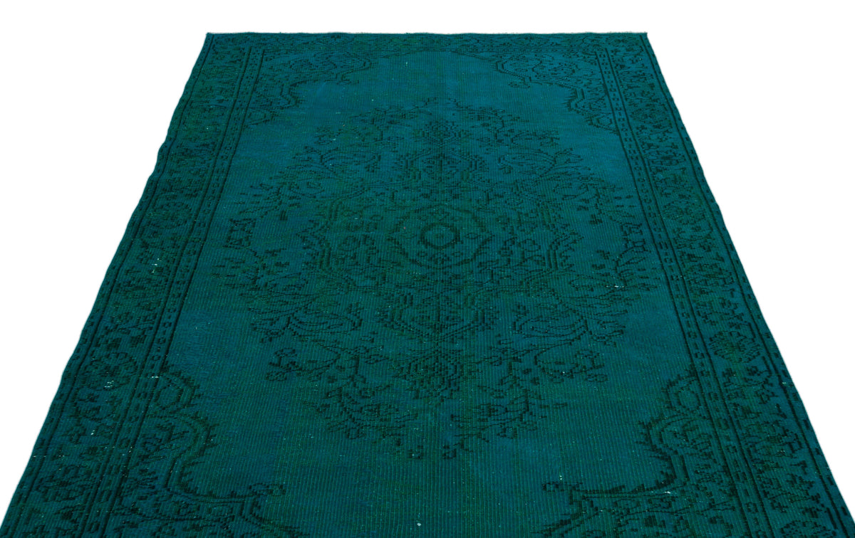Teal vintage-style rug with a dark green traditional floral medallion pattern on a white background.