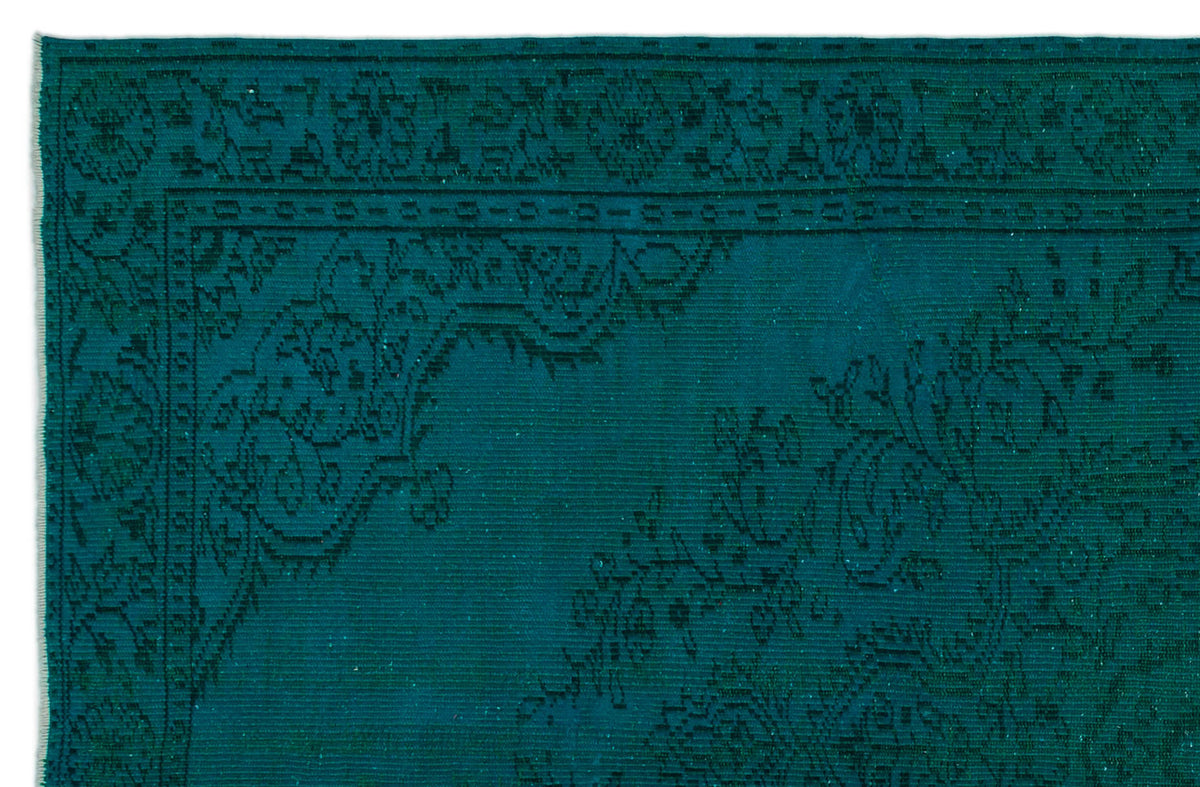 Teal rug with a dark, intricate traditional floral border and corner medallion pattern.