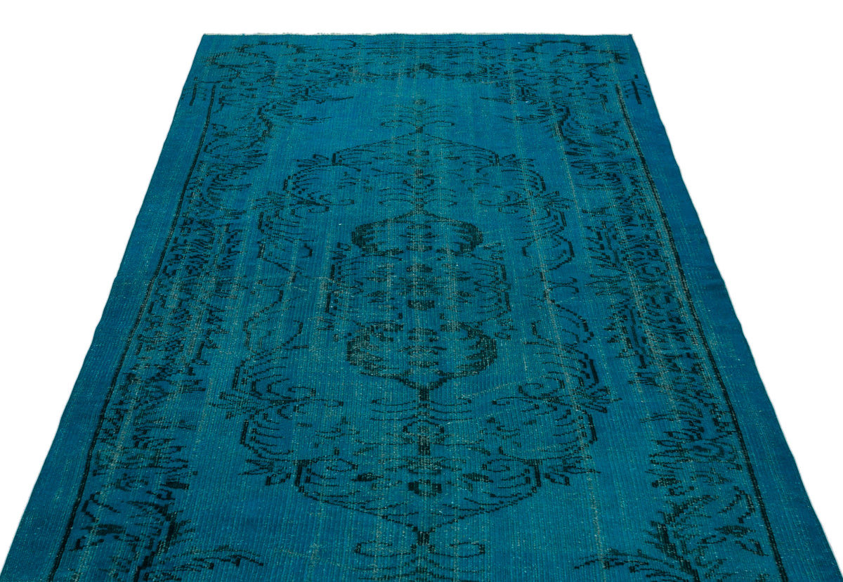 Teal rug with a black distressed traditional medallion pattern on a white background.