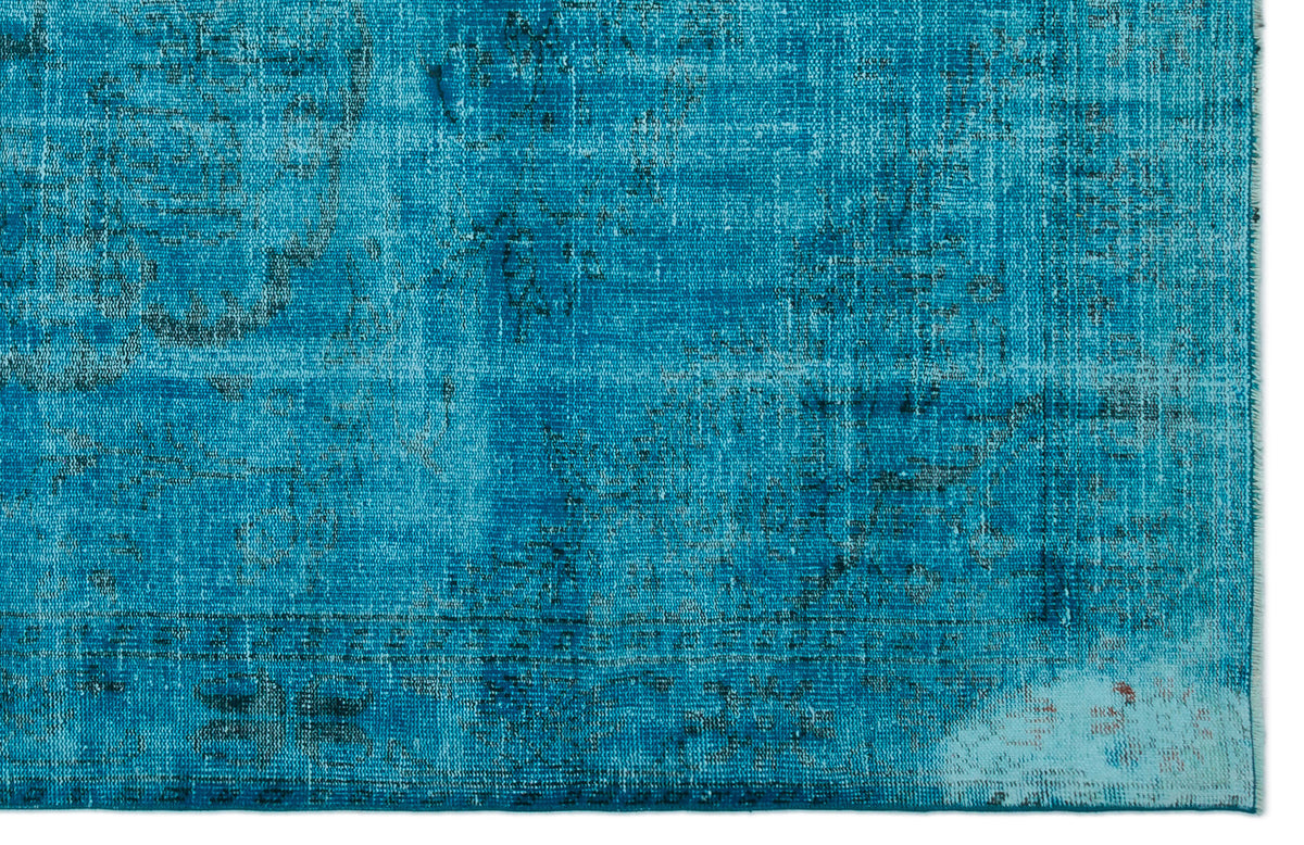 Bright turquoise distressed rug with a faded traditional medallion pattern and dark blue accents.