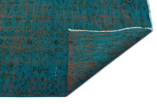 Load image 1 in gallery view. Teal and rust-orange distressed rug with a faded traditional pattern, shown with a corner folded over on a white background.