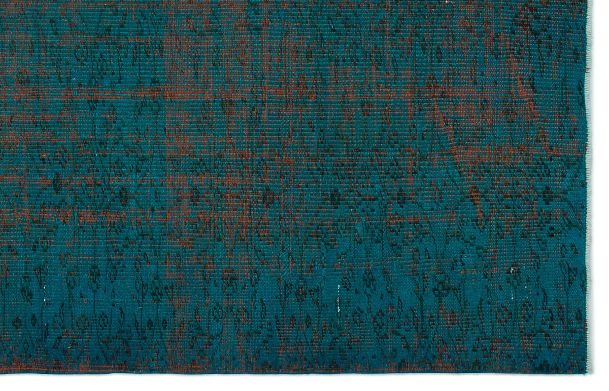 Teal and rust-colored distressed rug with a faded traditional floral pattern.