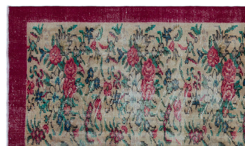 Load image 1 in gallery view. Beige vintage-style rug with a distressed floral pattern in red, teal, and blue, featuring a solid deep red border.