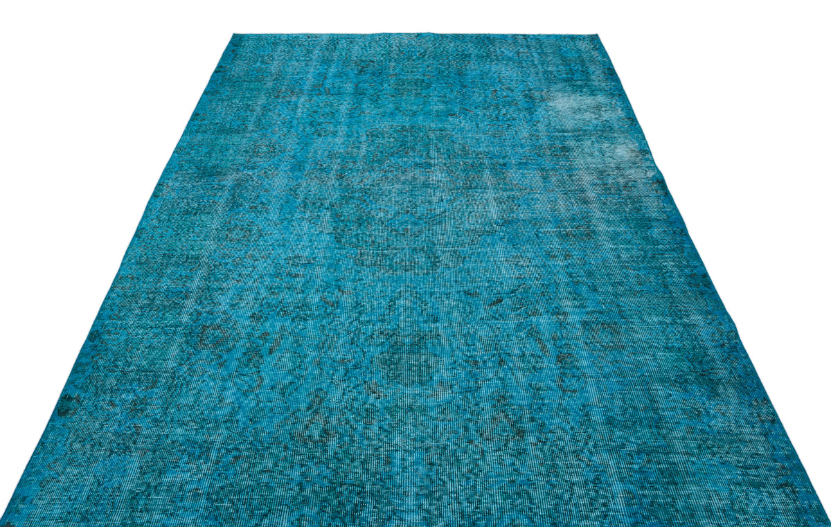 Bright turquoise distressed area rug with a faded traditional medallion pattern on a white background.