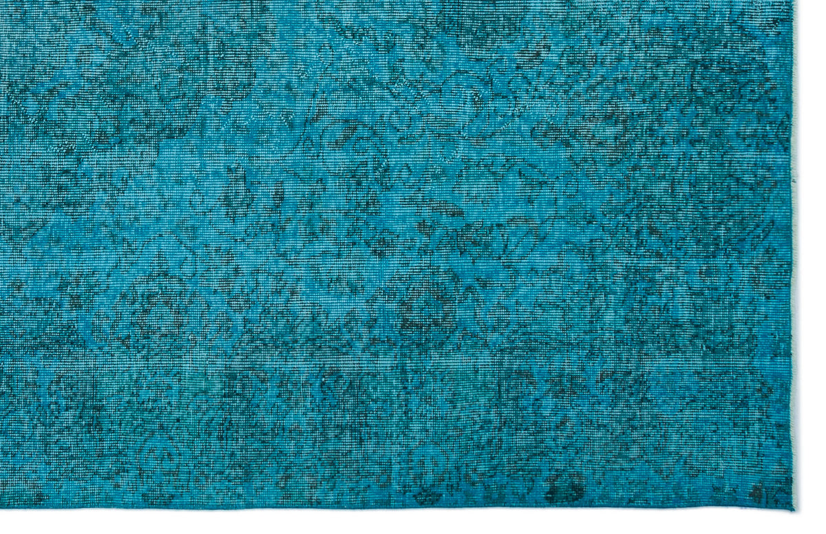 Teal and black distressed rug with a faded traditional floral medallion pattern.