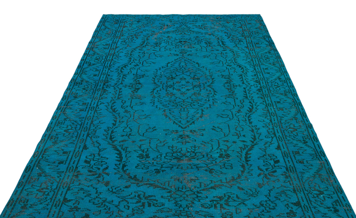 Teal rug with a black distressed traditional medallion pattern on a white background.