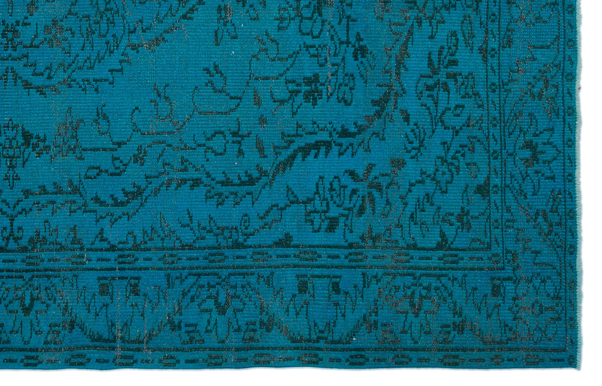 Teal rug with a dark charcoal traditional floral medallion pattern and a geometric border.