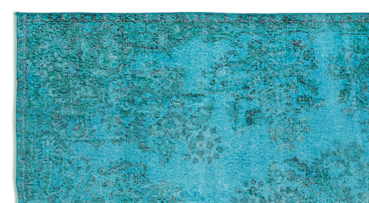 Turquoise and teal distressed rug with a faded traditional floral medallion pattern.