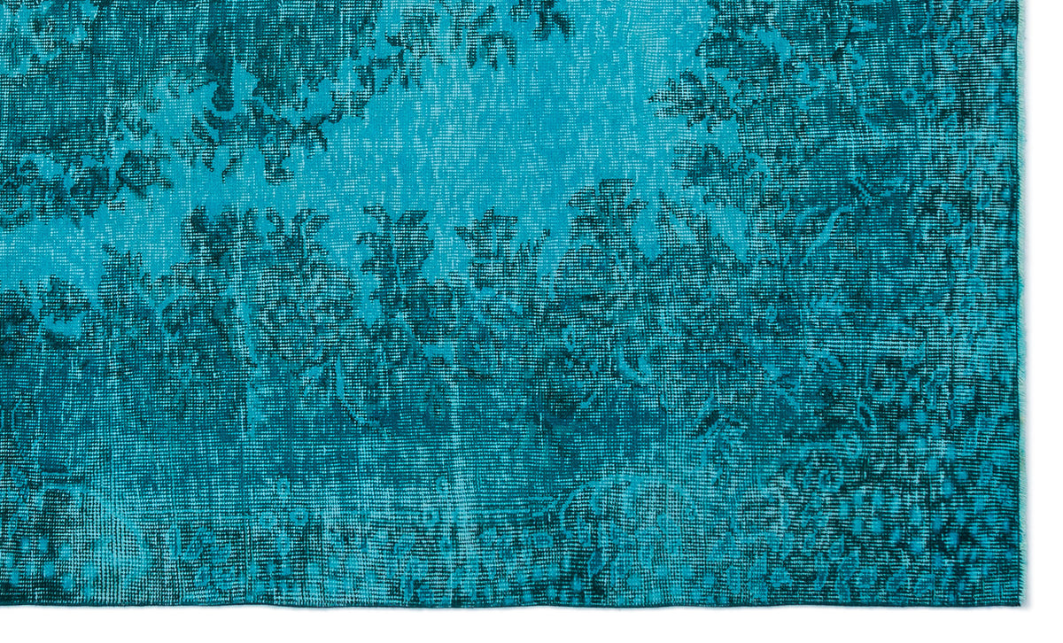 Teal and dark blue distressed rug with a faded traditional floral medallion pattern.
