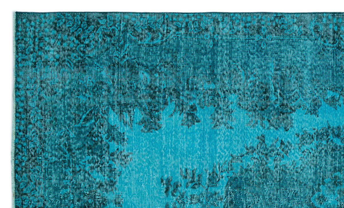 Teal and dark blue distressed rug with a faded traditional floral pattern.