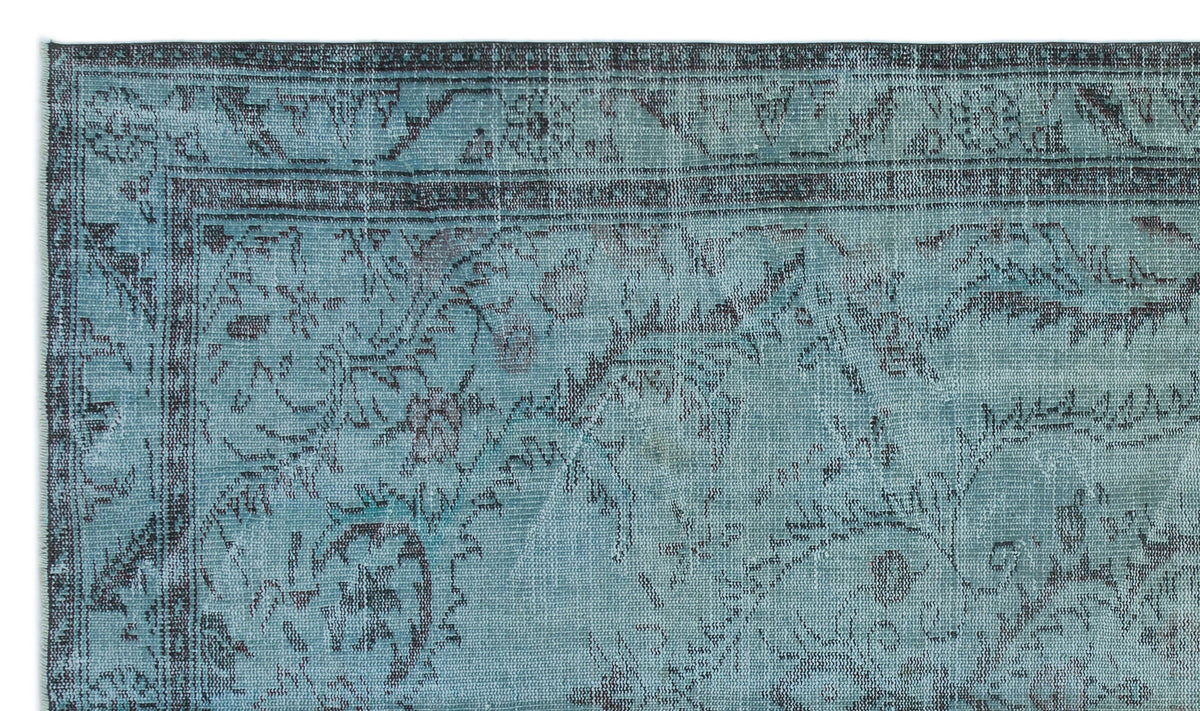 Teal and charcoal distressed rug with a traditional floral medallion pattern and a decorative border.