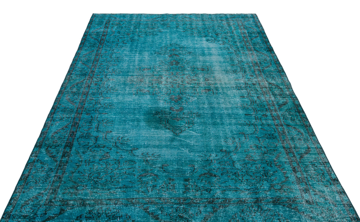 Teal distressed area rug with a faded traditional medallion pattern and dark border on a white background.