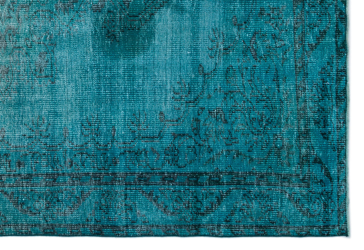 Teal and black distressed rug with a traditional floral medallion border pattern.