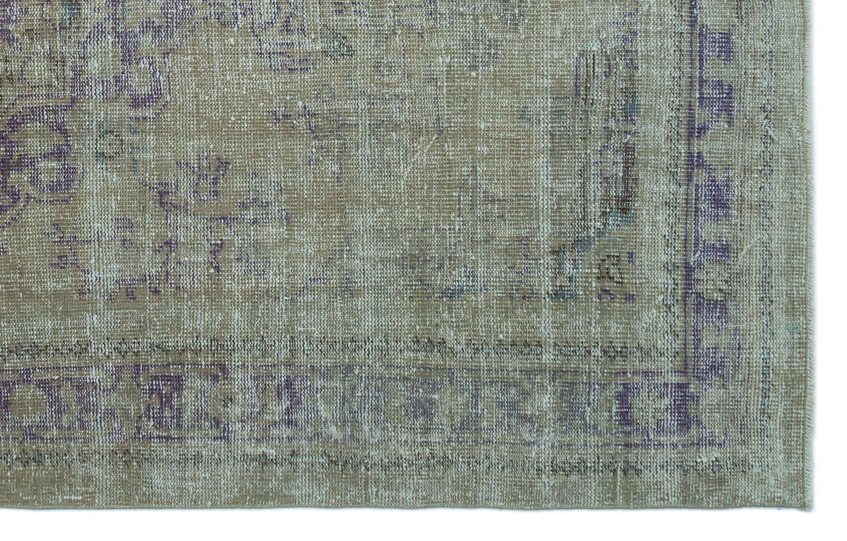Distressed beige and purple vintage-style rug with a faded traditional medallion pattern and a bordered edge.