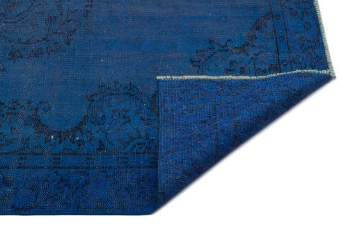 Load image 1 in gallery view. Deep blue rug with a black traditional floral medallion pattern and a folded corner revealing the underside.
