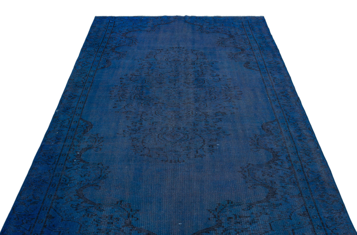 Monochromatic deep blue rug with a distressed traditional medallion pattern on a white background.