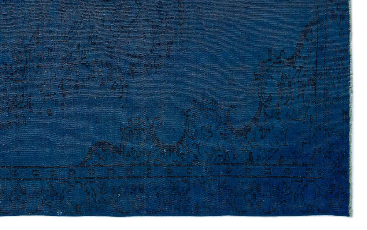 Deep blue rug with a subtle, dark-toned traditional floral border and medallion pattern.