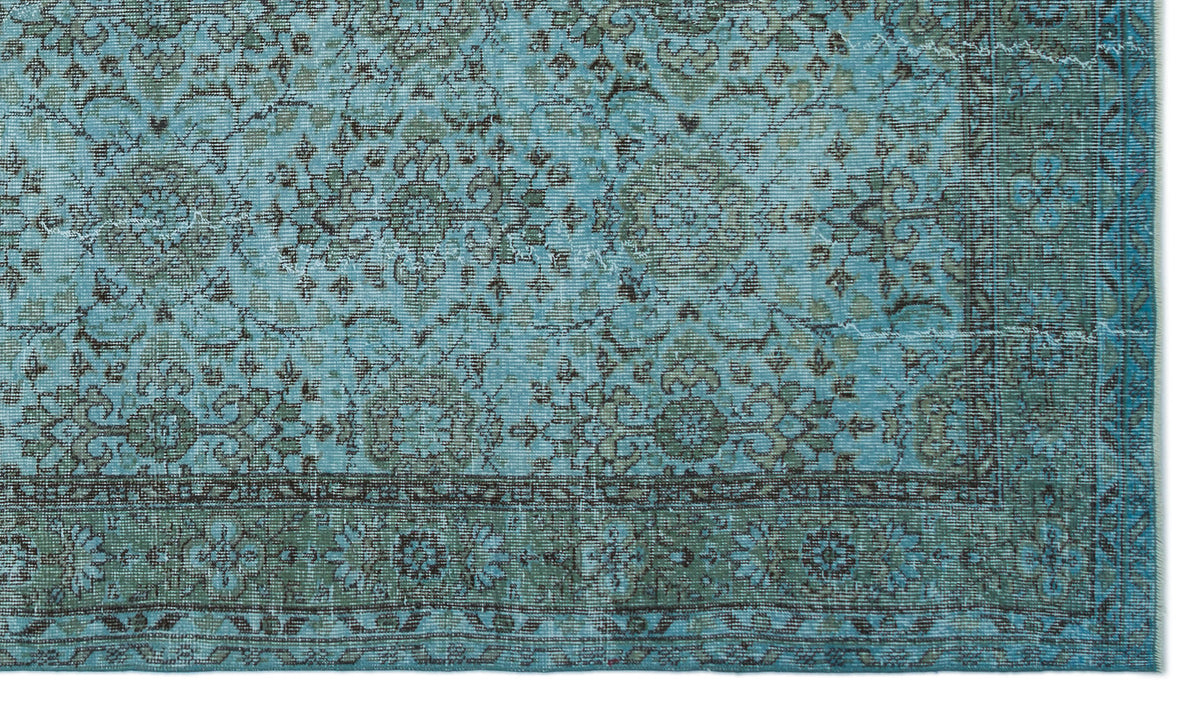 Distressed turquoise and sage green rug with a traditional floral medallion pattern and a detailed border.