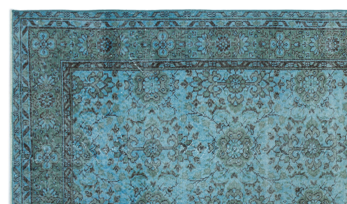 Teal and charcoal distressed rug with a traditional floral medallion pattern and a geometric border.