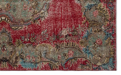 Load image 1 in gallery view. Distressed red rug with a faded floral medallion pattern in shades of taupe, blue, and pink.