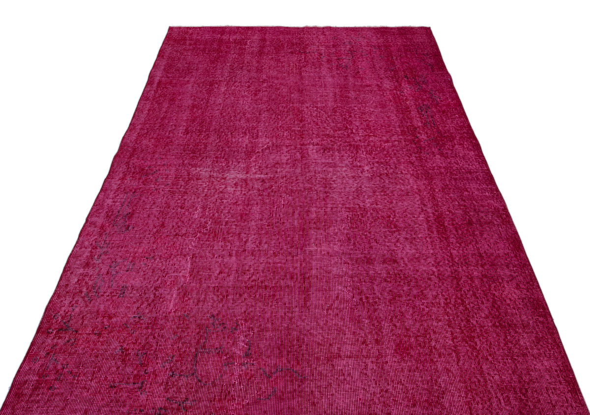 Magenta distressed vintage-style rug with subtle faded dark patterns on a white background.