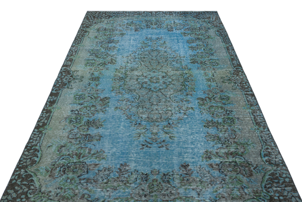 Distressed blue and grey traditional rug with a central floral medallion and ornate border pattern.
