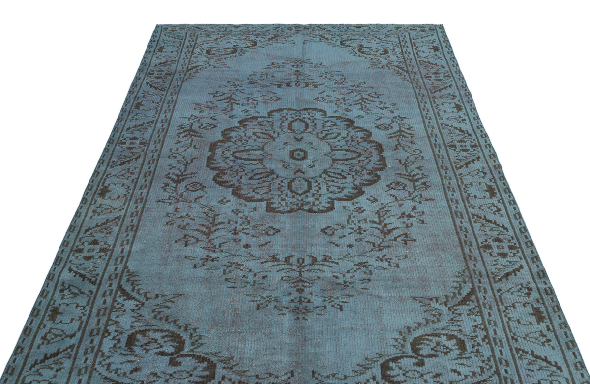 Blue and charcoal distressed rug with a central floral medallion and ornate border pattern on a white background.