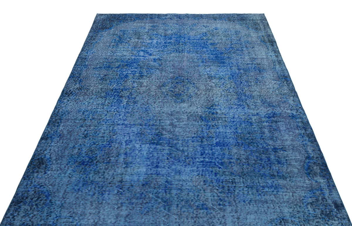 Deep blue distressed area rug with a faded traditional medallion pattern on a white background.
