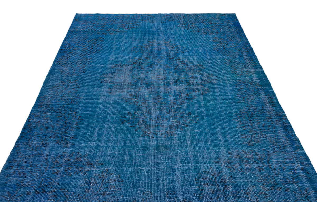 Distressed blue rug with a faded black central medallion and traditional ornate pattern on a white background.