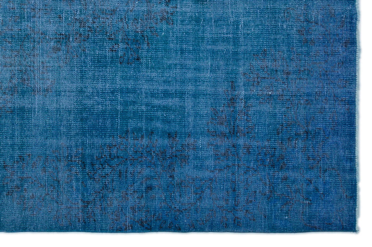Deep blue distressed rug with a faded, abstract vintage pattern on a white background.
