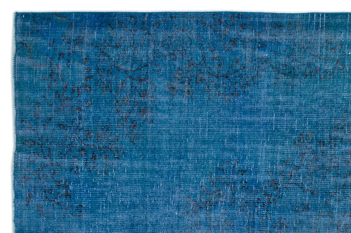 Deep blue distressed rug with a faded, dark charcoal floral pattern.