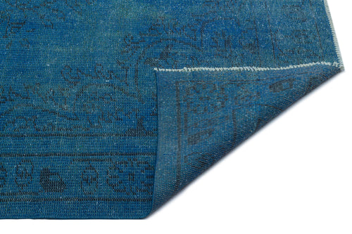 Load image 1 in gallery view. Blue distressed rug with a faded traditional medallion pattern, shown with a corner folded over on a white background.